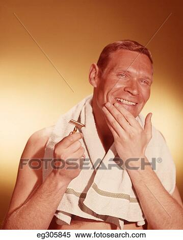 1960S Smiling Man Holding Razor Hand On Clean Shaven Chin Towel Around Neck View Large Photo Image Stock Photography - 1960S Smiling Man Holding Razor Hand On Clean Shaven Chin Towel Around Neck. Fotosearch