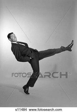 1960S Smiling Man Wearing A Suit Shirt & Tie Doing A Exaggerated Strut With Hands In His Pocket View Large Photo Image Picture - 1960S Smiling Man Wearing A Suit Shirt & Tie Doing A Exaggerated Strut With Hands In His Pocket . Fotosearch