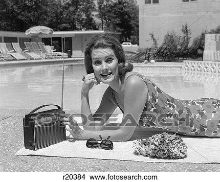 1960S Smiling Woman Bathing Suit By Swimming Pool Listening To Portable Radio View Large Photo Image Picture - 1960S Smiling Woman Bathing Suit By Swimming Pool Listening To Portable Radio. Fotosearch