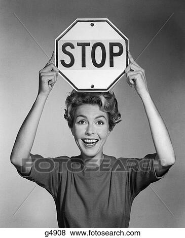 1960S Smiling Woman Holding Stop Sign Above Her Head View Large Photo Image Stock Photo - 1960S Smiling Woman Holding Stop Sign Above Her Head . Fotosearch