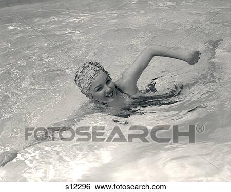 1960S Smiling Woman In Fancy Bathing Cap In Mid-Stroke Swimming In Pool View Large Photo Image Stock Photograph - 1960S Smiling Woman In Fancy Bathing Cap In Mid-Stroke Swimming In Pool . Fotosearch