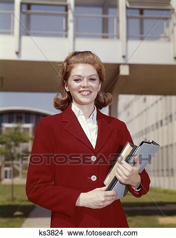 1960S Teen Girl Holding Books Wear Red Blazer Smiling At Camera Standing On Campus High School View Large Photo Image Picture - 1960S Teen Girl Holding Books Wear Red Blazer Smiling At Camera Standing On Campus High School. Fotosearch