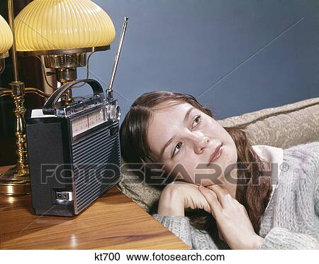 1960S Teen Girl Lying On Couch Listening To Transistor Radio Music Retro Vintage View Large Photo Image Stock Image - 1960S Teen Girl Lying On Couch Listening To Transistor Radio Music Retro Vintage. Fotosearch