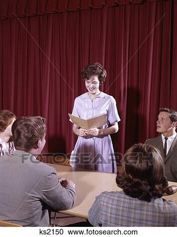 Stock Image - 1960S Teen Students At Conference Table In Front Of Red Velvet Curtain Girl Open Folder Speak Student Government Council. Fotosearch