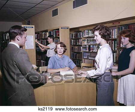 1960S Teen Students In Library At Check Out Desk Stacks Books Shelves Study Reference View Large Photo Image Stock Photo - 1960S Teen Students In Library At Check Out Desk Stacks Books Shelves Study Reference. Fotosearch