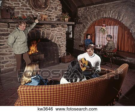 1960s Three Couples Men Women In Ski Lodge By Stone Fireplace Fire