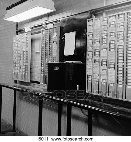 Stock Image - 1960S Time Clock & Card Slots In Large Factory . Fotosearch
