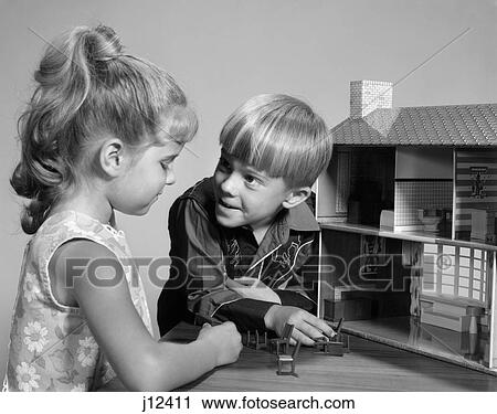 Stock Image - 1960S Two Kids Playing With Doll House Toy Girl With Pony Tail Boy In Western Shirt . Fotosearch