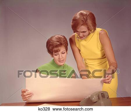 1960S Two Women Executives At Desk With Telephone Looking At Worksheet View Large Photo Image Stock Photo - 1960S Two Women Executives At Desk With Telephone Looking At Worksheet . Fotosearch