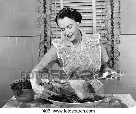 Stock Photograph - 1960S Woman In Apron Dishing Cranberry Sauce Out Around Turkey . Fotosearch