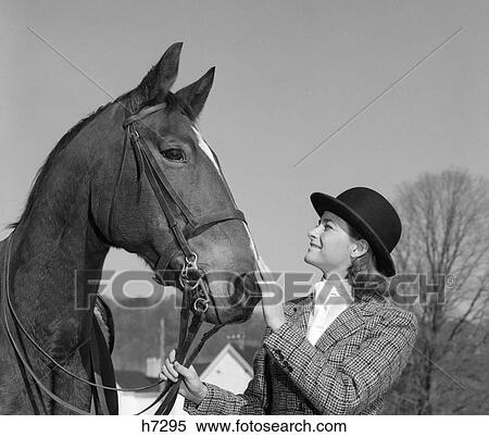 Stock Photography - 1960S Woman In English Riding Habit Holding Horse'S Reins & Petting Its Nose . Fotosearch