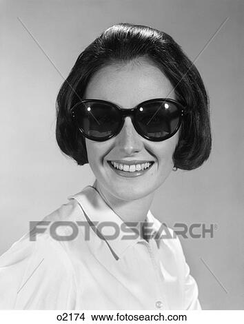 1960S Young Brunette Woman Smiling Wearing Large Sunglasses Retro View Large Photo Image Picture - 1960S Young Brunette Woman Smiling Wearing Large Sunglasses Retro . Fotosearch
