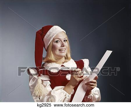 Stock Photography - 1960S Young Woman In Santa Helper Hat And Costume Holding Pen And List Symbolic Portrait . Fotosearch