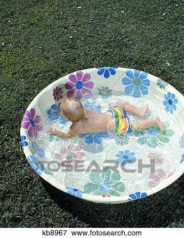 1970 1970S 1960 1960S Baby Playing Swim Swimming Plastic Flowered Design Wading Childs Backyard Pool Pool View Large Photo Image Stock Photo - 1970 1970S 1960 1960S Baby Playing Swim Swimming Plastic Flowered Design Wading Childs Backyard Pool Pool . Fotosearch