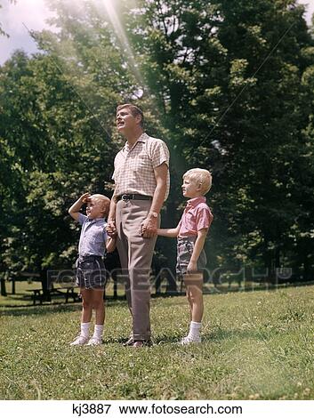 Father Sons Holding Hands Sunny Park 1960 1960S Retro View Large Photo Image Stock Photo - Father Sons Holding Hands Sunny Park 1960 1960S Retro. Fotosearch
