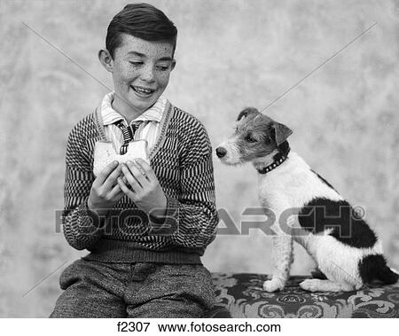 1920s 1930s boy eating sandwich as dog stares at food View Large Photo Image Stock Photo - 1920s 1930s boy eating sandwich as dog stares at food. Fotosearch
