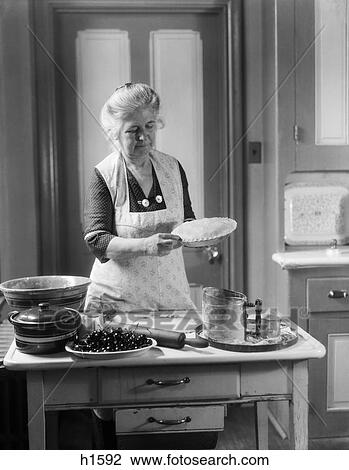 1920s 1930s woman grandmother wearing apron crimping crust making a cherry pie View Large Photo Image Stock Image - 1920s 1930s woman grandmother wearing apron crimping crust making a cherry pie. Fotosearch