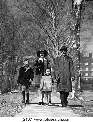 Stock Photo - 1930s 1940s family walking forward winter suburban sidewalk. Fotosearch