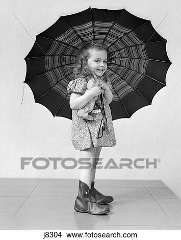 Picture - 1930s child holding rainy day umbrella. Fotosearch