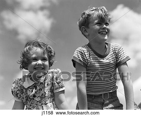 1930s smiling boy and girl bright summer day sky with clouds View Large Photo Image Stock Photo - 1930s smiling boy and girl bright summer day sky with clouds. Fotosearch