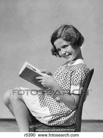 1930s smiling girl sitting in chair reading book View Large Photo Image Stock Image - 1930s smiling girl sitting in chair reading book. Fotosearch