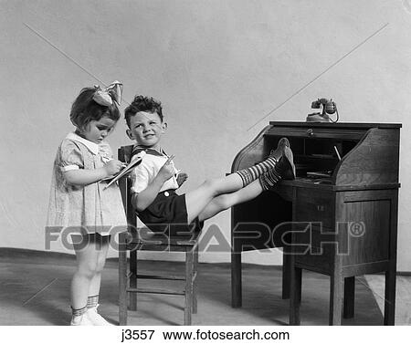 Stock Photo - 1930s two children playing office desk secretary boss. Fotosearch