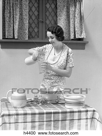 1930s woman milk pour kitchen dairy View Large Photo Image Stock Image - 1930s woman milk pour kitchen dairy. Fotosearch