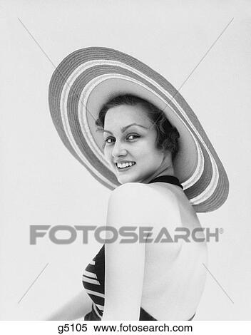 1930s woman wearing striped halter top and very wide brim straw hat looking at camera over shoulder View Large Photo Image Stock Photography - 1930s woman wearing striped halter top and very wide brim straw hat looking at camera over shoulder. Fotosearch