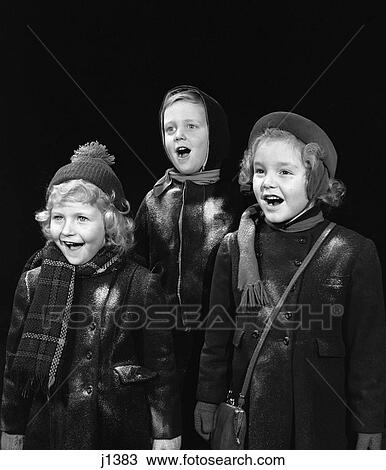 Stock Image - 1940, 1940s children signing caroling. Fotosearch
