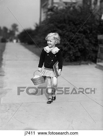 1940s child holding basket books walking sidewalk View Large Photo Image Stock Image - 1940s child holding basket books walking sidewalk. Fotosearch