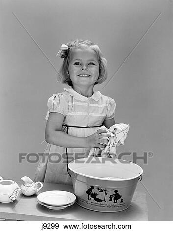 1940s child washing dishes drying smiling View Large Photo Image Stock Photo - 1940s child washing dishes drying smiling. Fotosearch