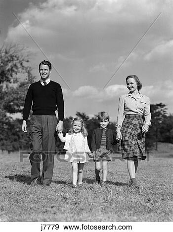 1940s family holding hands walking on grass View Large Photo Image Stock Photo - 1940s family holding hands walking on grass. Fotosearch
