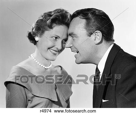 1950s 1960s couple man woman smiling posed head to head foreheads touching love trust flirt man suit tie woman scoop neck dress pearls earrings View Large Photo Image Picture - 1950s 1960s couple man woman smiling posed head to head foreheads touching love trust flirt man suit tie woman scoop neck dress pearls earrings. Fotosearch