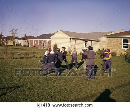 1950s 1960s group neighborhood boys play touch football backyard suburban houses View Large Photo Image Stock Photo - 1950s 1960s group neighborhood boys play touch football backyard suburban houses. Fotosearch