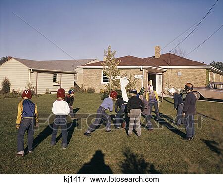 1950s 1960s group of boys playing touch football in suburban neighborhood house yard View Large Photo Image Stock Photo - 1950s 1960s group of boys playing touch football in suburban neighborhood house yard. Fotosearch