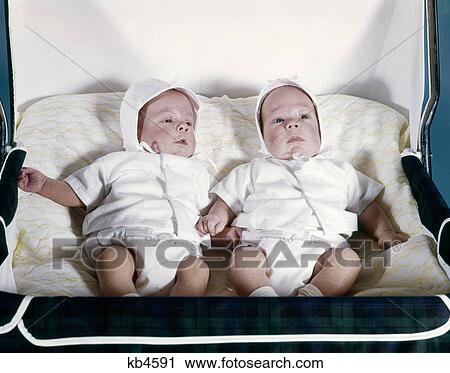 1950s 1960s twin boys dressed in white lying in stroller side by side View Large Photo Image Stock Image - 1950s 1960s twin boys dressed in white lying in stroller side by side. Fotosearch