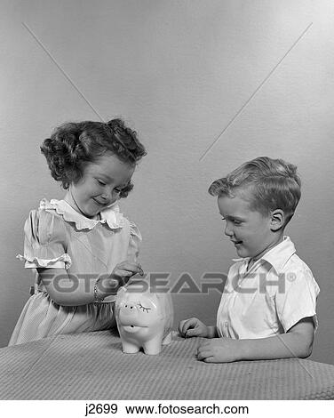 1950s child children putting money into piggy bank View Large Photo Image Stock Photo - 1950s child children putting money into piggy bank. Fotosearch