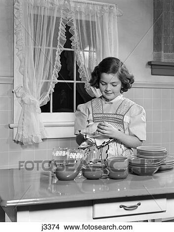 1950s child drying dishes kitchen table View Large Photo Image Picture - 1950s child drying dishes kitchen table. Fotosearch