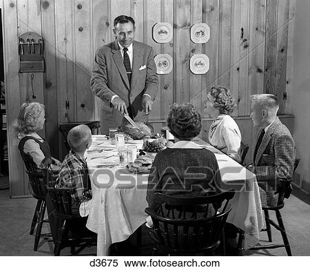 1950s father standing at dinner table knotty pine paneled dining room ready to serve family and carve turkey View Large Photo Image Stock Photography - 1950s father standing at dinner table knotty pine paneled dining room ready to serve family and carve turkey. Fotosearch