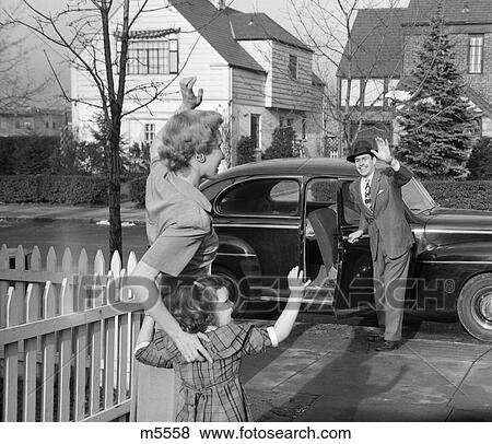 Stock Photo - 1950s mother and daughter waving to father opening automobile door in front of suburban home. Fotosearch