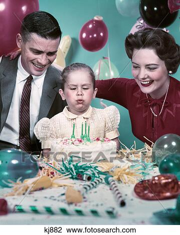 1950s mother father daughter blowing out candles on birthday cake View Large Photo Image Stock Image - 1950s mother father daughter blowing out candles on birthday cake. Fotosearch