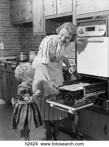 1950s smiling mother daughter in kitchen broiling pork chops View Large Photo Image Picture - 1950s smiling mother daughter in kitchen broiling pork chops. Fotosearch