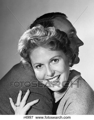 1950s smiling woman hugging man head on his shoulder View Large Photo Image Stock Photo - 1950s smiling woman hugging man head on his shoulder. Fotosearch
