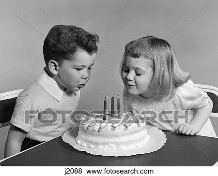 1950s two children blowing out birthday candles View Large Photo Image Stock Photo - 1950s two children blowing out birthday candles. Fotosearch