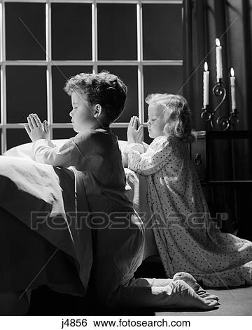 1950s two children praying kneeling night View Large Photo Image Stock Photograph - 1950s two children praying kneeling night. Fotosearch