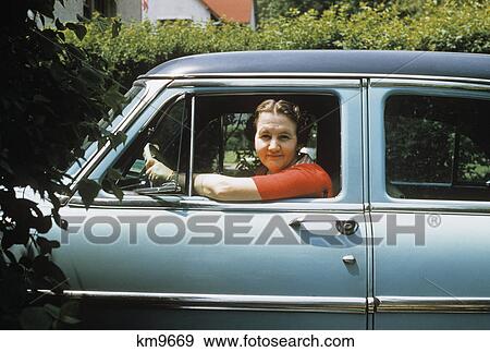 Stock Photo - 1950s woman driver looking out of car window. Fotosearch