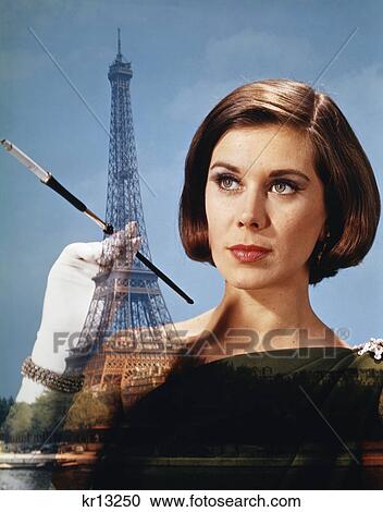 1960s 1970s composite elegant woman hold cigarette holder against paris scene eiffel tower View Large Photo Image Stock Image - 1960s 1970s composite elegant woman hold cigarette holder against paris scene eiffel tower. Fotosearch