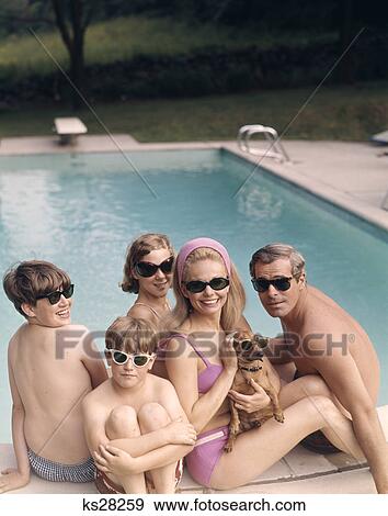 1960s 1970s family all wearing sunglasses beside swimming pool View Large Photo Image Stock Photo - 1960s 1970s family all wearing sunglasses beside swimming pool. Fotosearch