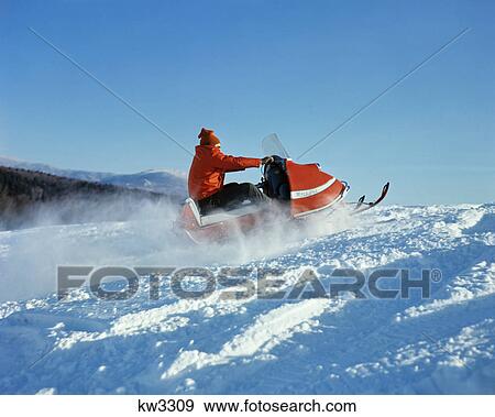 1960s 1970s man wearing red jacket and hat driving snowmobile View Large Photo Image Stock Photo - 1960s 1970s man wearing red jacket and hat driving snowmobile. Fotosearch