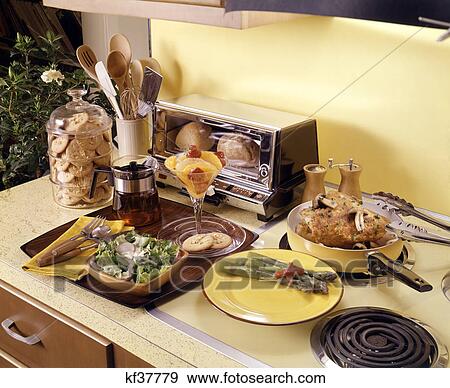 1960s 1970s meal prepared with kitchen appliances vintage chicken potato salad asparagus tea fruit cocktail cookies View Large Photo Image Stock Photo - 1960s 1970s meal prepared with kitchen appliances vintage chicken potato salad asparagus tea fruit cocktail cookies. Fotosearch
